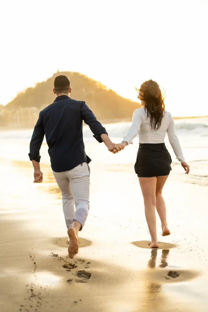 Happy-couple-holding-hands-running-along-a-beach-during-sunset - Finding Peace Counseling Service PLLC Happy couple holding hands running along a beach during sunset