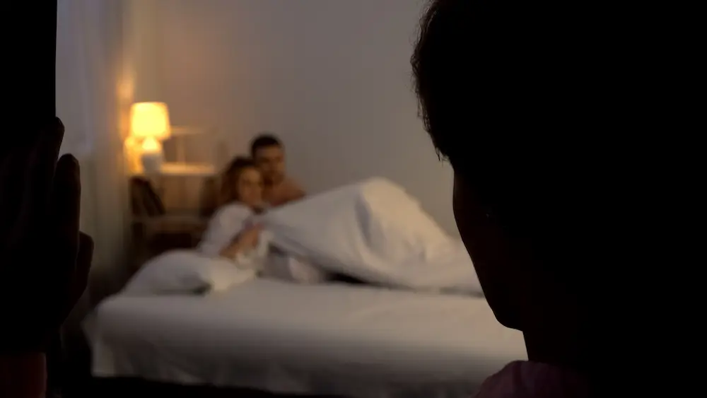 Person witnessing a partner in bed with someone else - Finding Peace Counseling Service PLLC - Finding Peace Counseling Service PLLC Person witnessing a partner in bed with someone else, illustrating the discovery and emotional impact of infidelity.