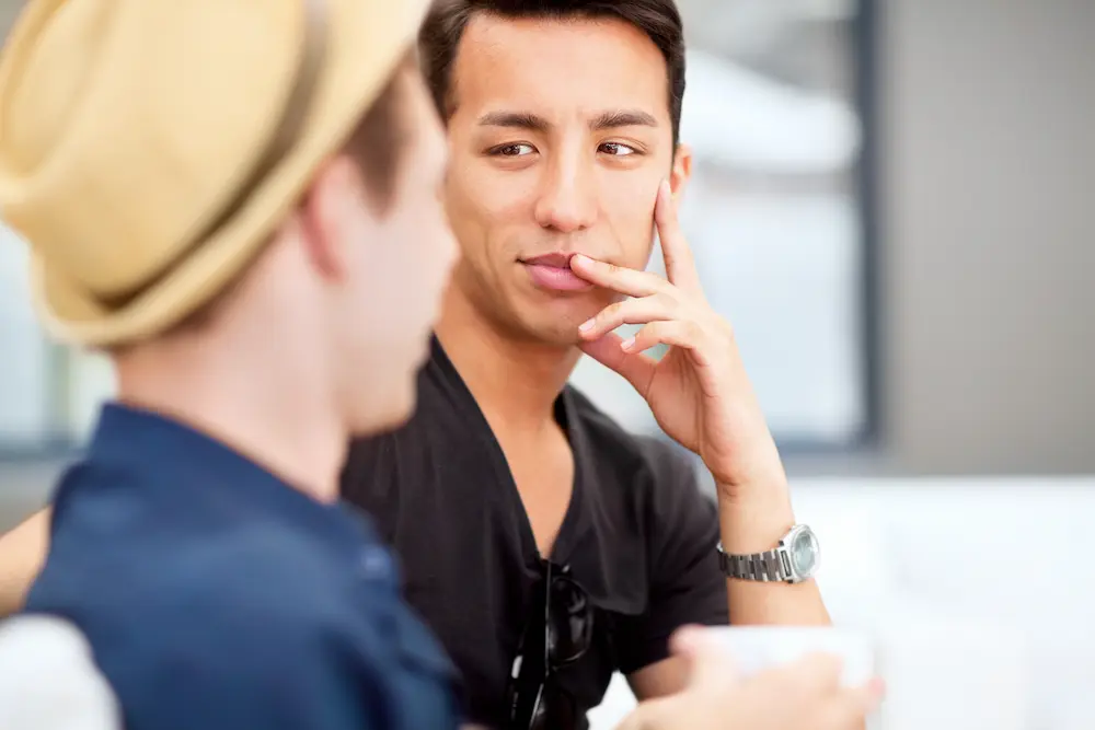 Two men having a serious face-to-face conversation, with one listening thoughtfully while maintaining eye contact with the other.